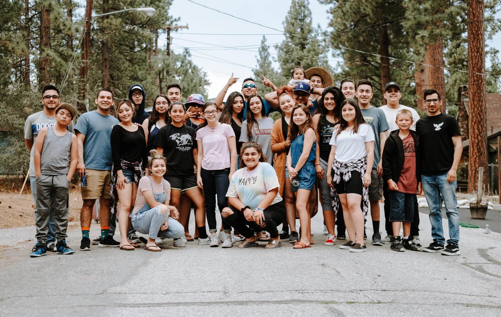 Photo by Omar Lopez group of people taking photo near brown wooden tree
